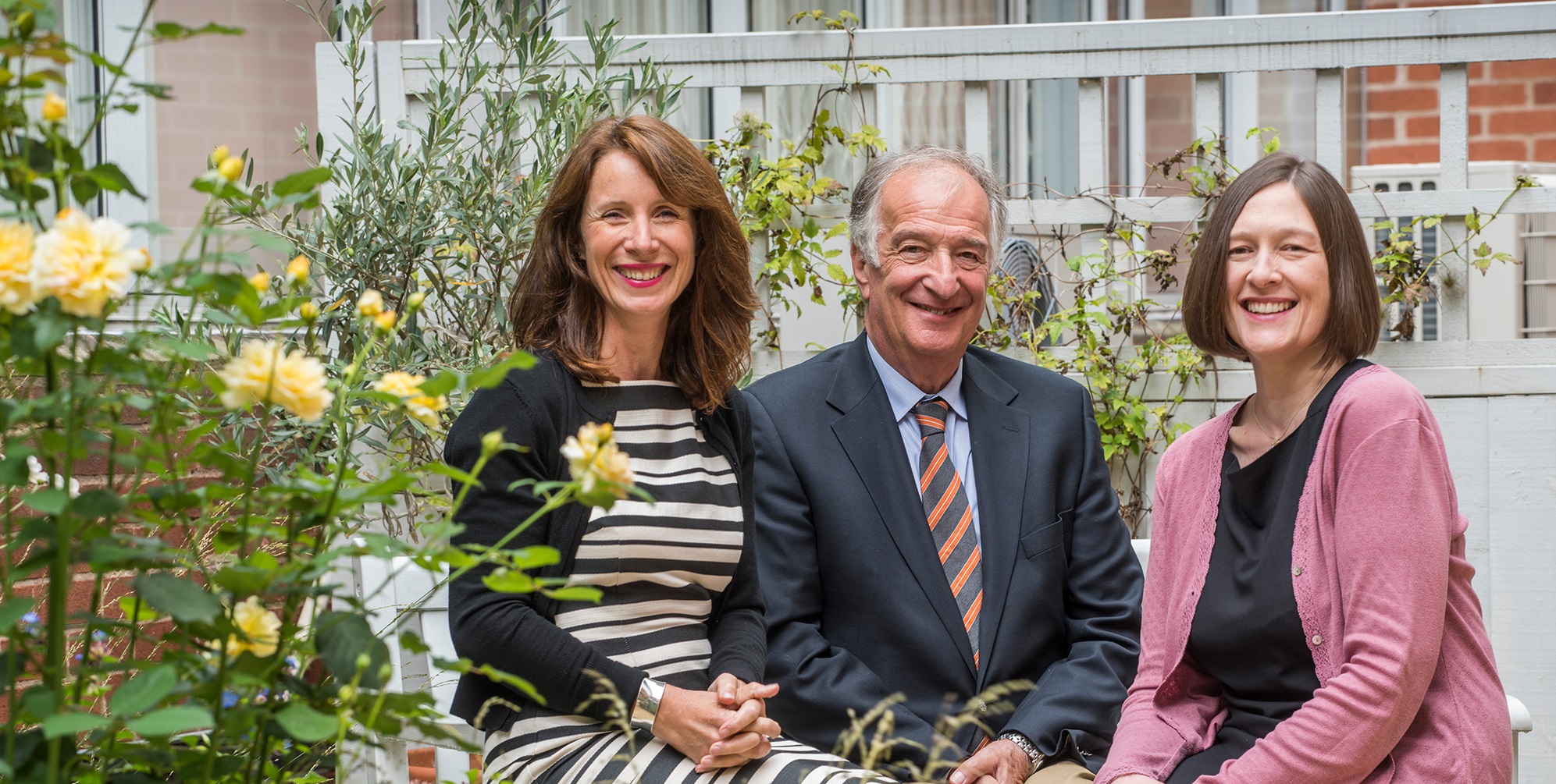 Three board members sitting and smiling at camera