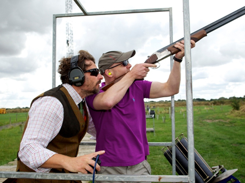 Man teaching another man how to shoot