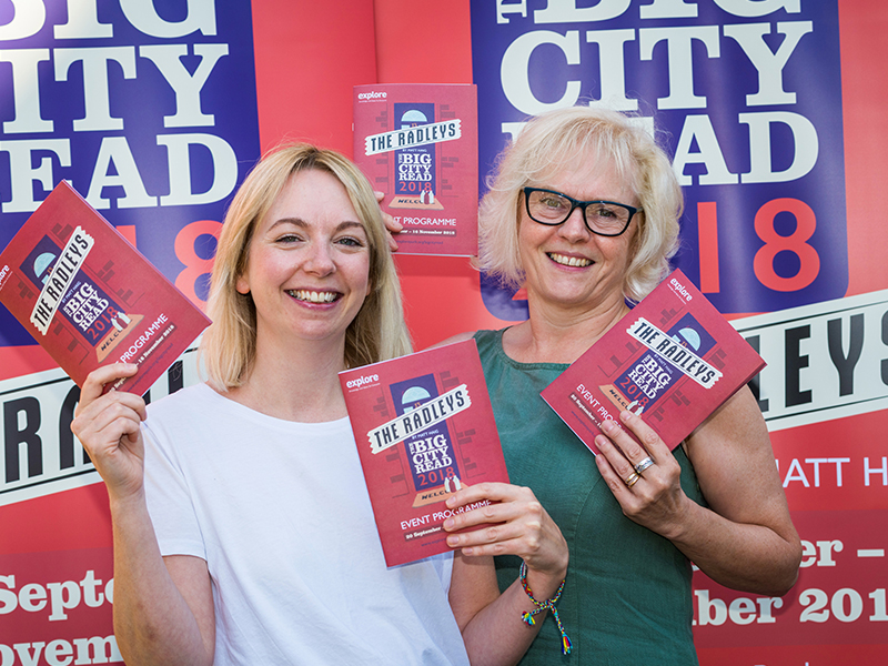 Women holding up Big City Read 2018 pamphlets