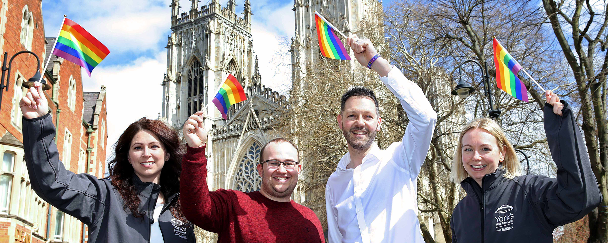 TalkTalk team at York Minster waving Pride flags