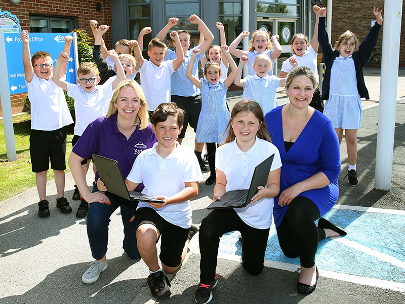 Marketing Manager Helen Fletcher with Hob Moor Primary School students and laptops