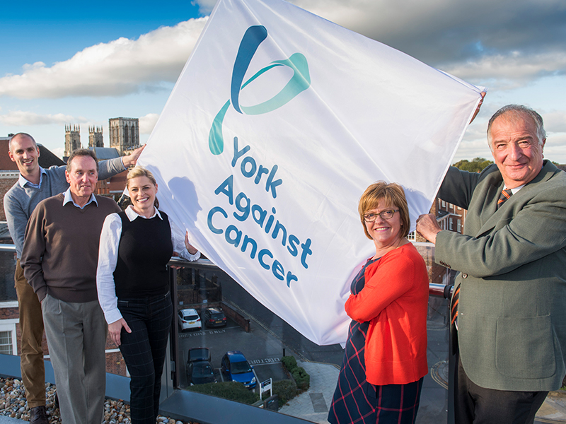 York Against Cancer team holding up York Against Cancer flag